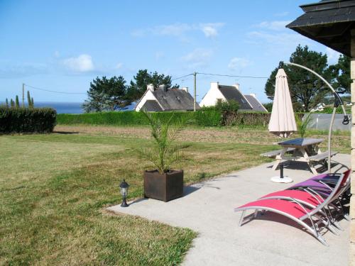 eine Terrasse mit einem Tisch, Stühlen und einem Sonnenschirm in der Unterkunft Holiday Home Milin-Avel - TGM102 by Interhome in Telgruc-sur-Mer