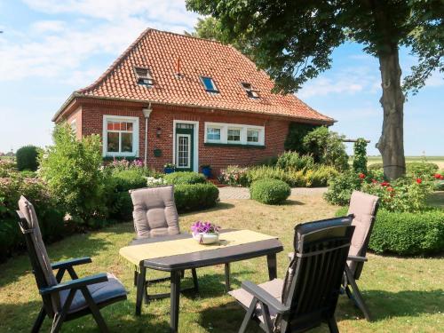 a table and chairs in front of a house at Apartment Huuske am Polder by Interhome in Ditzumerhammrich