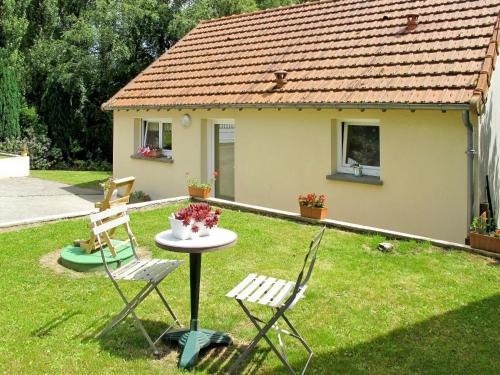 stół i dwa krzesła w ogrodzie z domem w obiekcie Holiday Home de Beaumont - NCA400 by Interhome w mieście Carentan