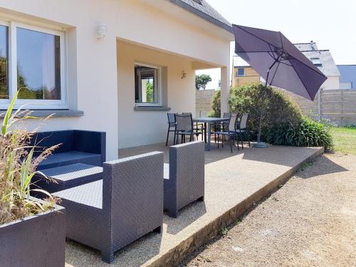 eine Terrasse mit einem Sonnenschirm, einem Tisch und Stühlen in der Unterkunft Holiday Home de la Plage by Interhome in Pleubian