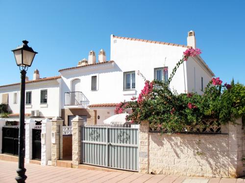 uma casa branca com um portão e flores em Holiday Home Playa del Conde by Interhome em Chilches