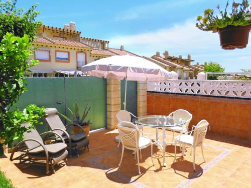 un patio con mesa, sillas y sombrilla en Holiday Home Playa del Conde by Interhome en Chilches