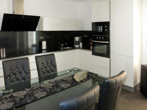 a kitchen with a glass table and chairs at Holiday Home Ingeborg by Interhome in Vilafortuny