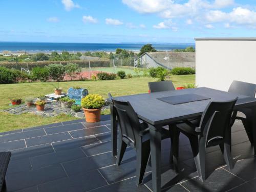 een zwarte tafel en stoelen op een patio met uitzicht op de oceaan bij Holiday Home L'Iroise - PTP102 by Interhome in Pentrez