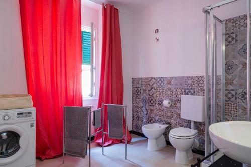 a bathroom with red curtains and a washing machine at A pochi passi da Piazza de Ferrari by Wonderful Italy in Genoa