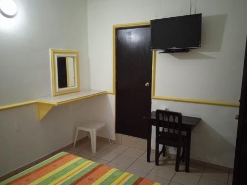 a room with a desk and a door and a chair at Hotel Kiko in Mazatlán