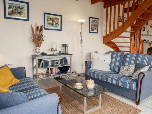 un salon avec deux canapés bleus et une table dans l'établissement Holiday Home Pors Bae by Interhome, à Primelin