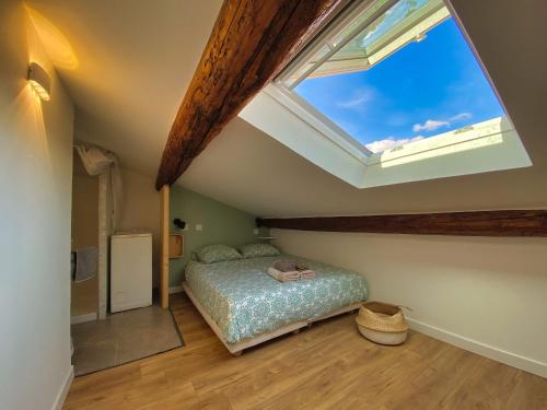 une chambre avec un lit et une grande fenêtre dans l'établissement # CLIM - TRAM - Centre ville - Sous les toits #, à Montpellier