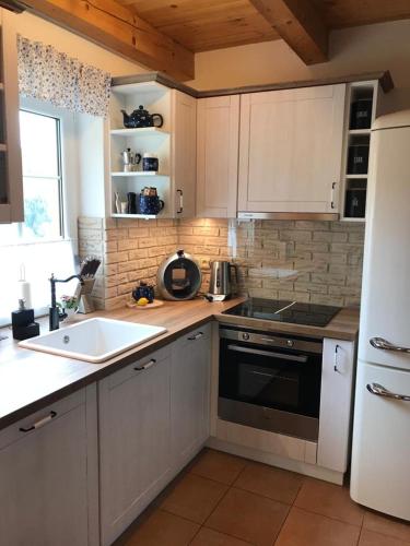 a kitchen with a sink and a white refrigerator at CHALUPA NA VYHLÍDCE in Jeseník