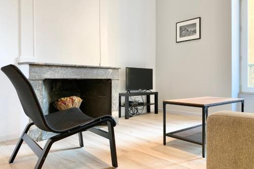 a living room with a chair and a fireplace at Le best-seller de Majordome #BC in Grenoble