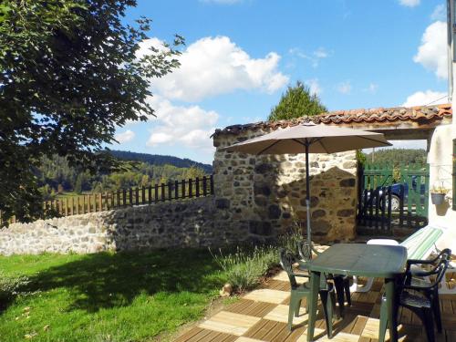 a patio with a table and an umbrella at Holiday Home Le Haut d'Ancette - AJA100 by Interhome in Saint-Julien-dʼAnce