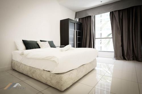 a white bedroom with a large bed and a window at Marina Times Square Homestay by Evernent in Miri