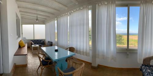 un soggiorno con tavolo e alcune finestre di Da u Franchin a Carloforte