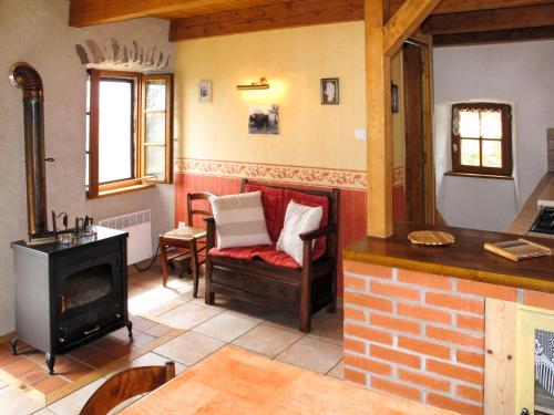 een woonkamer met een open haard, een stoel en een fornuis bij Holiday Home Chez Nancy - ABE300 by Interhome in Blesle