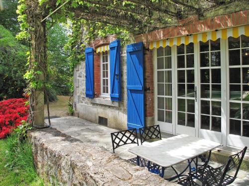 een tafel en stoelen buiten een huis met blauwe deuren bij Holiday Home La Terrade - CUI100 by Interhome in Lépinas