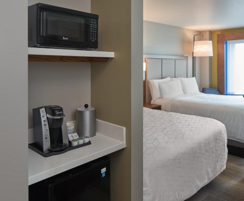 a hotel room with a bed and a tv on a wall at Holiday Inn Express Doral Miami by IHG in Doral