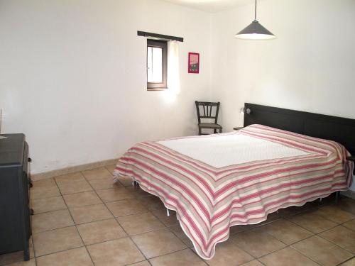 - une chambre avec un lit doté d'une couverture rayée dans l'établissement Holiday Home Marguerie by Interhome, à La Touche