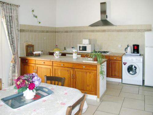 a kitchen with a table and a stove and a microwave at Holiday Home Les Vignes by Interhome in Ménerbes