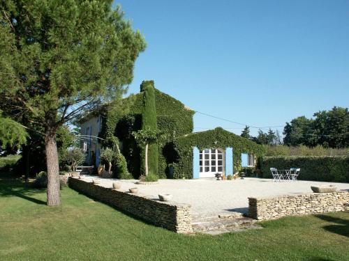 a house covered in ivy with a patio at Holiday Home Les Puits Neufs by Interhome in Cavaillon