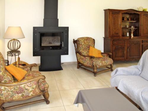 - un salon avec deux chaises et une cheminée dans l'établissement Holiday Home Les Lilas Blancs - VRS205, à Valréas