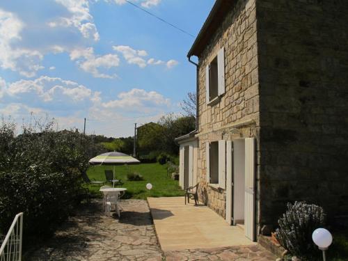 a stone house with an umbrella and a patio at Holiday Home Les Lauriers Roses - LRG490 by Interhome in Montréal