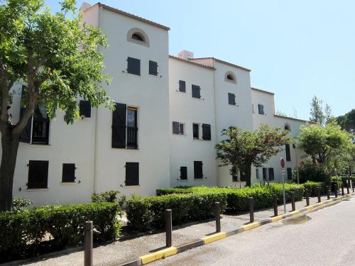 un bâtiment blanc avec des fenêtres noires et une rue dans l'établissement Apartment Port d'Attache-8 by Interhome, à Saint Cyprien Plage