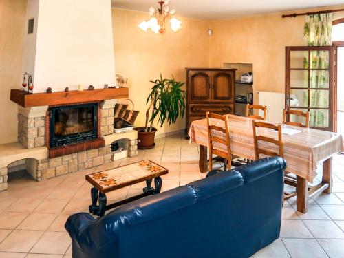 ein Wohnzimmer mit einem Tisch und einem Kamin in der Unterkunft Holiday Home Le Mas - GRG201 by Interhome in Grillon