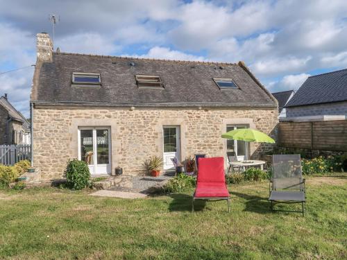 une maison avec deux chaises et un parasol vert dans l'établissement Holiday Home Ty Breiz by Interhome, à Ploemeur