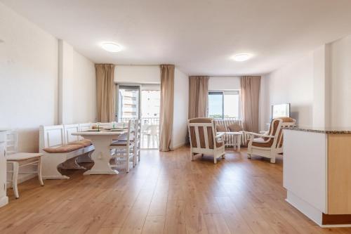 a salon with white chairs and a table and a room at Apartamento Vora Mar 33 in Cambrils