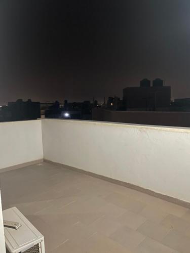 a room with a white wall and a city skyline at Chambre SEJOUR in Dakar