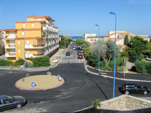 une rue de la ville avec des voitures garées sur la route dans l'établissement Apartment Les Cigalines-1 by Interhome, à Narbonne-Plage