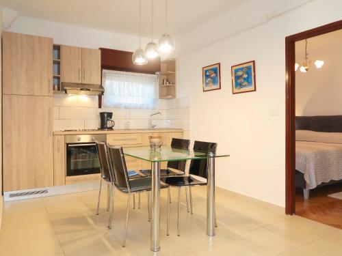 a kitchen and dining room with a glass table and chairs at Apartment Vesna - PUT106 by Interhome in Punat