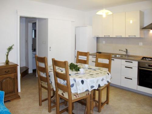 a kitchen with a table and chairs in a kitchen at Holiday Home Antica - PUT103 by Interhome in Punat