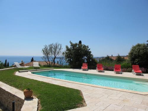 サナリー・シュル・メールにあるHoliday Home Baie de Bandol - SAY110 by Interhomeの赤い椅子と海を望むスイミングプール