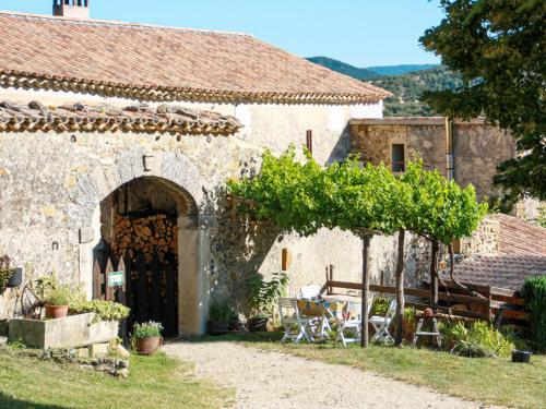 an old stone building with an archway in a yard at Holiday Home Le Buis - RSB101 by Interhome in Roche-Saint-Secret