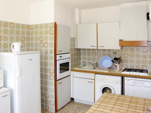 シス・フール・レ・プラージュにあるHoliday Home La Pitchoune - SFP100 by Interhomeのキッチン(白いキャビネット、白い冷蔵庫付)