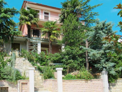 a pink house on a brick wall with trees at Holiday Home Noel by Interhome in Raša