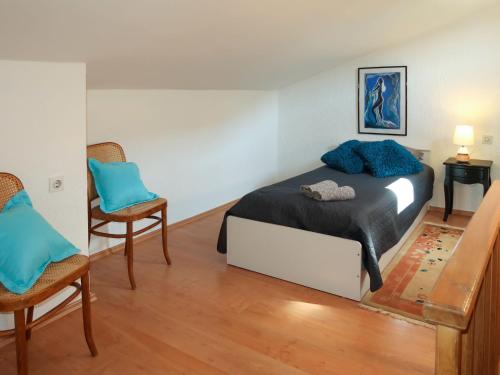 a bedroom with a bed with blue pillows on it at Holiday Home Noel by Interhome in Raša