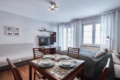 un soggiorno con tavolo, divano e letto di Apartamenty Świnoujście - Villa Park a Świnoujście