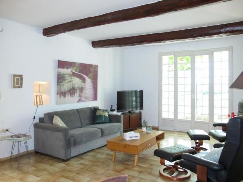 a living room with a couch and a table at Holiday Home Mas de l'Adrech by Interhome in Fayence
