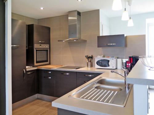 une cuisine avec un évier et un micro-ondes dans l'établissement Holiday Home Les Quatrevais by Interhome, à Cancale