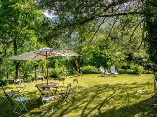 a table and chairs and an umbrella in a yard at Holiday Home Villa Biino by Interhome in Ala di Stura