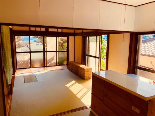 cocina con encimera y ventanas grandes en Guest House Nagasaki 1 御船蔵の我が家 1, en Nagasaki