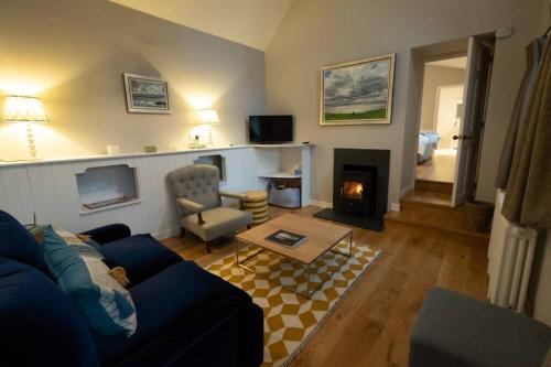 a living room with a blue couch and a fireplace at Portree, Isle of Skye in Portree