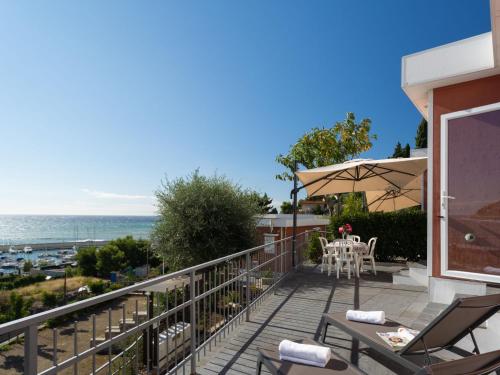 einen Balkon mit einem Tisch, Stühlen und Meerblick in der Unterkunft Holiday Home Bouganvilla - SLR402 by Interhome in San Lorenzo al Mare