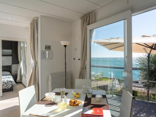 ein Esszimmer mit einem Tisch und Meerblick in der Unterkunft Holiday Home Bouganvilla - SLR402 by Interhome in San Lorenzo al Mare