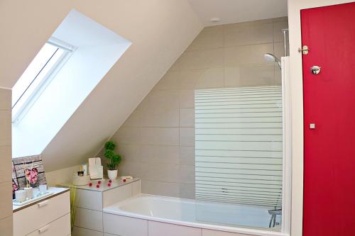 een badkamer met een groot bad op zolder bij La pause gourmande charme et confort au centre ville in Molsheim