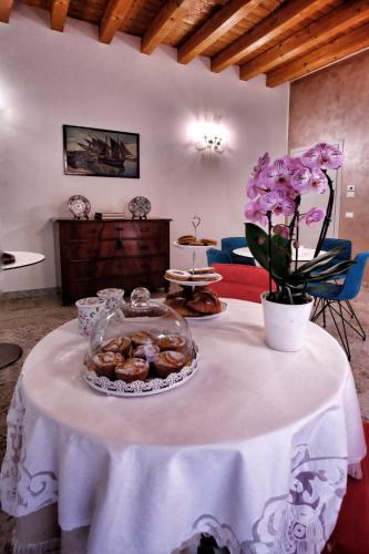 a table with a plate of donuts and flowers on it at Corte Trento in Desenzano del Garda