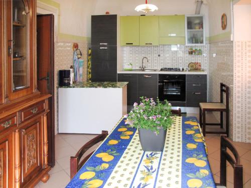 una cocina con una mesa con un jarrón de flores. en Apartment Roma - SLR219 by Interhome, en Cipressa