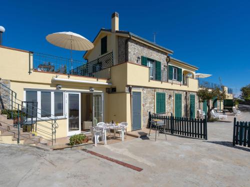 uma casa com uma varanda e uma mesa com um guarda-chuva em Apartment Primavera - PGI132 by Interhome em Poggi